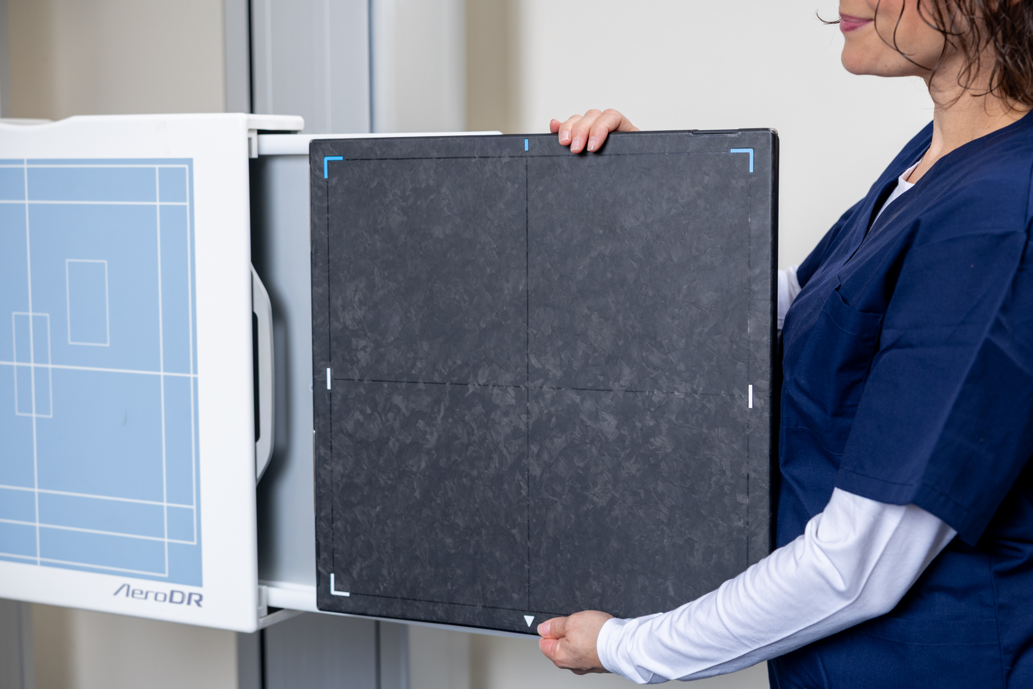 A Radiology Technician is setting up to use an AeroDR X-ray panel.