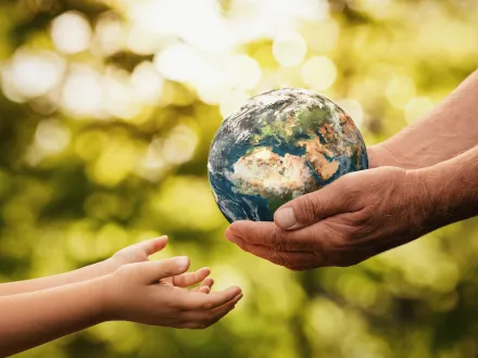 parents hands handing the world to a child