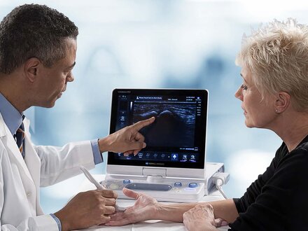 Doctor reviewing ultrasound with patient on an HS1 device