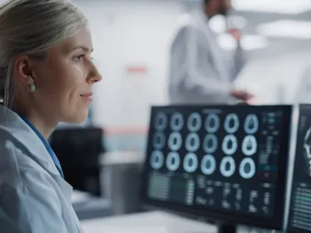 A Radiologist reading scans on a computer monitor