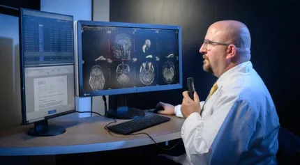 A radiologist viewing patient images on dual computer monitors