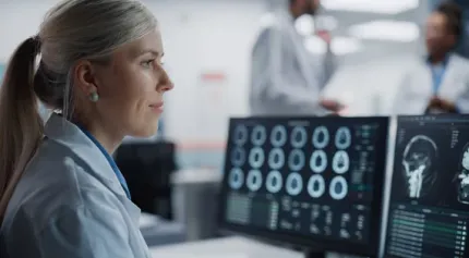 A Radiologist reading scans on a computer monitor
