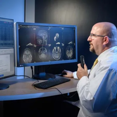 A radiologist viewing patient images on dual computer monitors