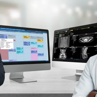 A Woman using a RIS System and a Radiologist using a PACS System side by side smiling